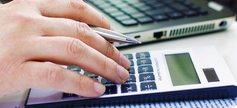 um homem usa a calculadora retratando a importância do cálculo de depreciação